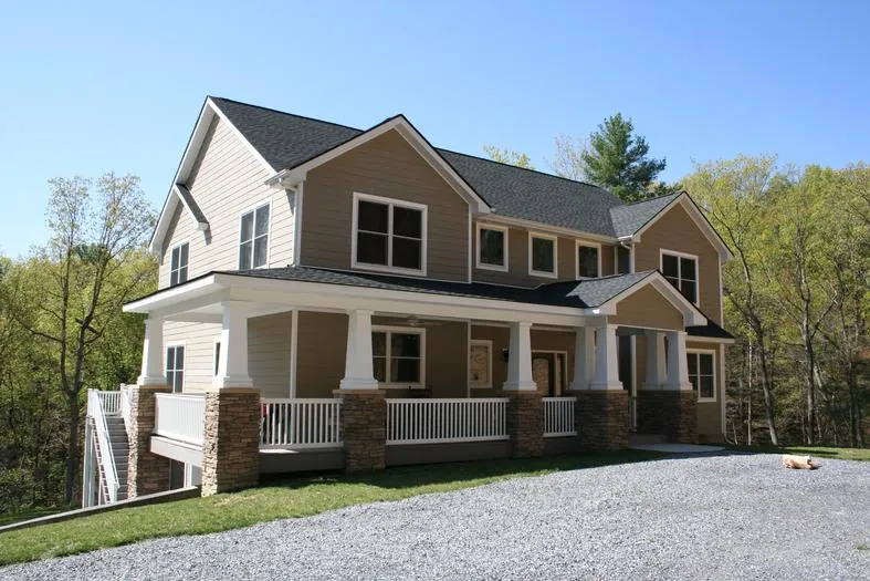 Two-story home with a stone base, a covered front porch, and a second-floor balcony.